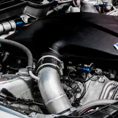 Widok na sportowy silnik BMW z widocznymi elementami układu dolotowego. Może to być przestroga przed tym, jak wyglądają zatarty silnik objawy.