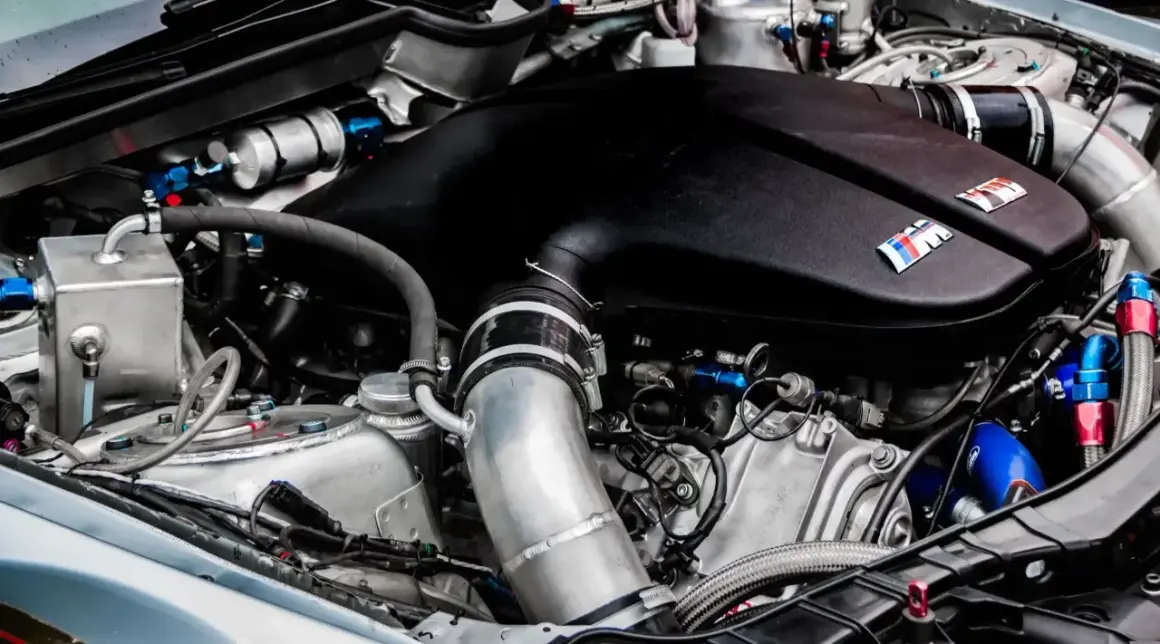 Widok na sportowy silnik BMW z widocznymi elementami układu dolotowego. Może to być przestroga przed tym, jak wyglądają zatarty silnik objawy.