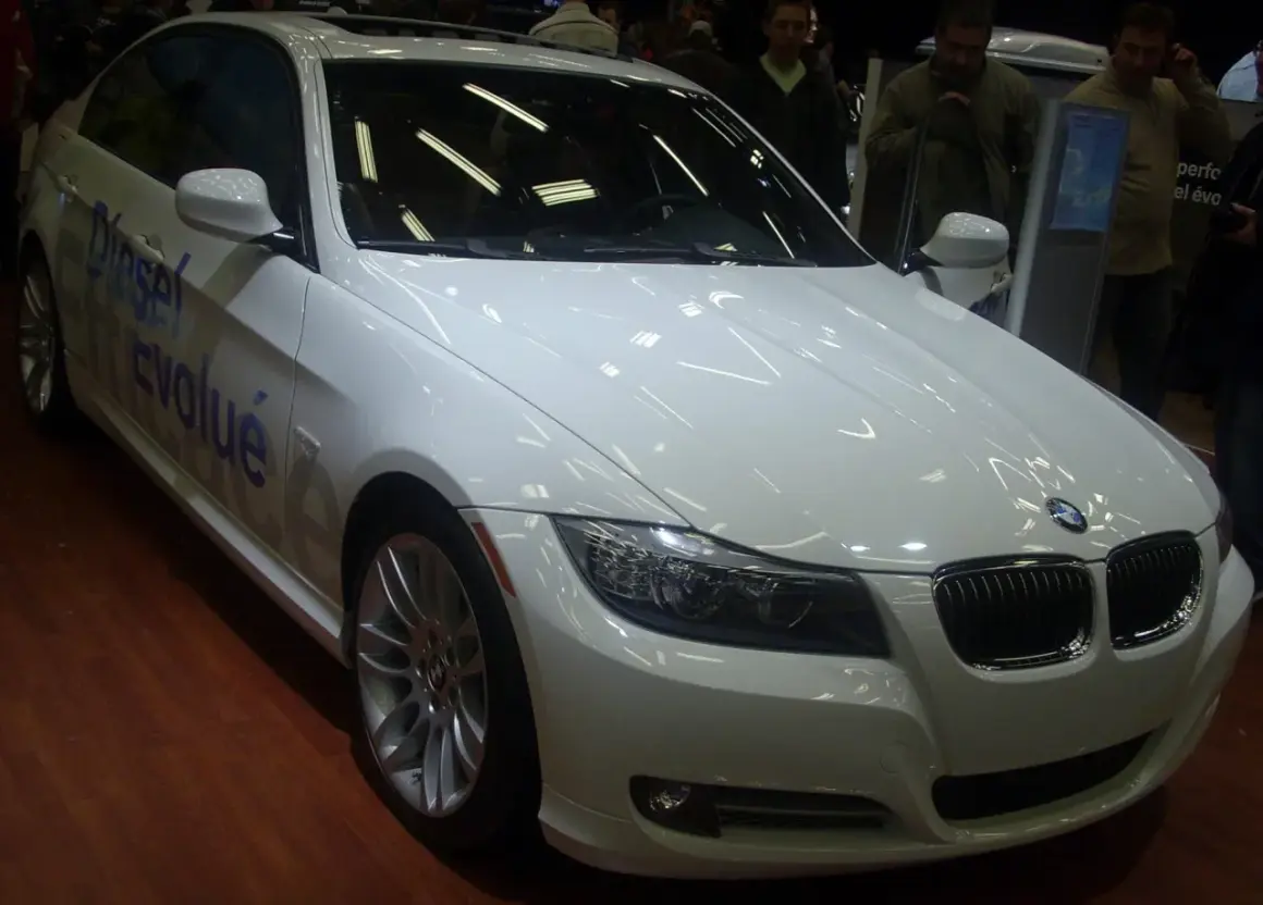Białe BMW E92 335is z napisem "Diesel Evolué" na drzwiach, prezentowane na wystawie.