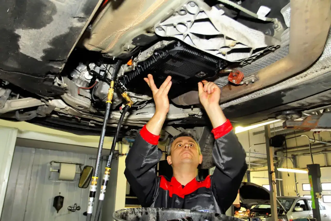 mechanik wymienia olej w automatycznej skrzyni bieg&oacute;w